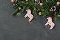 Christmas dark holiday background, natural decorations set in a composition with hand made toy horses, spruce branches, pinecones
