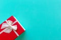 Christmas Day gift box with a red bow on blue green wall background, top view and copy space. Royalty Free Stock Photo