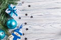 Christmas decor with blue balls, wrapped present and glazed snowman cookie on white wooden background with copyspace Royalty Free Stock Photo