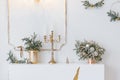 Christmas decor in a classic living room or bedroom in bright colors. Spruce branches in gold vases with toys and a gold