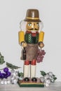 Christmas decor - German winemaker nutcracker with grapes and bottle of wine with grapes arranged around him against white