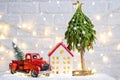 Christmas decor red retro car pickup truck on snow with fairy lights in bokeh Christmas tree. New Year greeting card. Cozy home Royalty Free Stock Photo