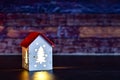 Christmas decor. Small Christmas house with glowing windows from the inside. toy in the form of house with illuminated windows Royalty Free Stock Photo