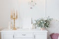 Christmas decor white chest of drawers in the bedroom or living room, candlestick, spruce arrangement