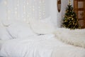 Christmas decorated bedroom interior with comfortable bed, Christmas fir tree and gift boxes on floor, copy space. Cozy Royalty Free Stock Photo