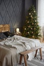 Christmas decorated bedroom interior with comfortable bed, Christmas fir tree and gift boxes on floor, copy space. Royalty Free Stock Photo