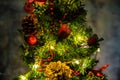 Christmas decorated small tree with red and gold decorations slowly lights up a light chain wrapped around a tree of yellow color Royalty Free Stock Photo