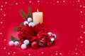 Christmas decoration. Flower of red poinsettia, branch christmas tree, ball, candle, red berries, snow on a red background Royalty Free Stock Photo