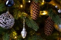 Christmas decoration balls branch. Christmas tree toy on spruce branches. Blue, gray, shiny toy ball and pine cone on the