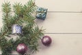 Christmas decoration baubles with branches of fir tree on light wooden background Royalty Free Stock Photo