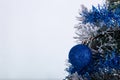 Christmas decoration blue ball in a tree with tinsel and pinecone in snow Royalty Free Stock Photo