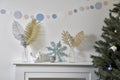 Christmas decoration: blue faux glitter snowflake, candle holder and porcelain white figurine bullfinch bird stand on the console Royalty Free Stock Photo