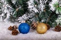 Christmas decoration blue and gold balls in a tree with tinsel and pinecone in snow Royalty Free Stock Photo