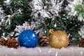 Christmas decoration blue and gold balls in a tree with tinsel and pinecone in snow Royalty Free Stock Photo