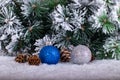 Christmas decoration blue and silver balls in a tree with tinsel and pinecone in snow Royalty Free Stock Photo