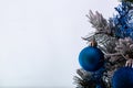 Christmas decoration blue and silver balls in a tree with tinsel and pinecone in snow Royalty Free Stock Photo
