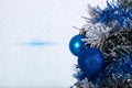 Christmas decoration blue and silver balls in a tree with tinsel and pinecone in snow Royalty Free Stock Photo