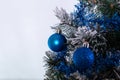 Christmas decoration blue and silver balls in a tree with tinsel and pinecone in snow Royalty Free Stock Photo