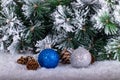 Christmas decoration blue and silver balls in a tree with tinsel and pinecone in snow Royalty Free Stock Photo