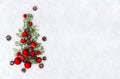 Christmas decoration. Branch christmas tree, christmas balls, berries and cones pine on snow. Top view, flat lay Royalty Free Stock Photo