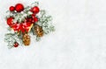 Christmas decoration. Branch christmas tree, christmas bells, red balls, red berries and cones spruce on snow. Top view, flat lay Royalty Free Stock Photo