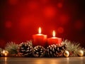 Christmas decoration with burning candles and fir cones on wooden table over red background Royalty Free Stock Photo