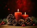 Christmas decoration with burning candles and fir cones on wooden table over red background Royalty Free Stock Photo