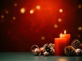 Christmas decoration with burning candles and fir cones on wooden table over red background Royalty Free Stock Photo