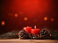 Christmas decoration with burning candles and fir cones on wooden table over red background Royalty Free Stock Photo