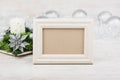 Christmas decoration with candle and empty photo frame on white wooden background. White frame mock-up Royalty Free Stock Photo