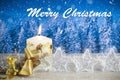 Christmas decoration with candle, golden bow, silver stars, with text in English `Merry Christmas` in a blue forest background Royalty Free Stock Photo