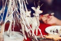 Christmas decoration concept. Vintage toy - christmas deer - with bow on its neck standing over white christmas tree in restaurant