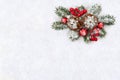 Christmas decoration. Cones pine, twigs christmas tree, red balls, red berries on snow with space for text. Top view, flat lay Royalty Free Stock Photo