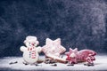 Christmas decoration and cookies.Woman hand sprinkling sugar on a cookies. Flour and spices for a baking on a dark backg Royalty Free Stock Photo
