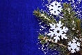Christmas decoration.Decorative felt snowflakes and snowy fir tree branch on blue background with copyspace. Royalty Free Stock Photo
