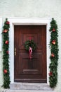 Christmas decoration of the door with a beautiful traditional wreath. Celebrating Christmas, decorating the house. Royalty Free Stock Photo