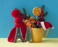 Christmas decoration with eiffel tower statue in red scraf and hat on colorful paper background. Holiday background with copy