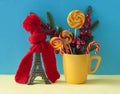 Christmas decoration with eiffel tower statue in red scraf and hat on colorful paper background. Holiday background with copy