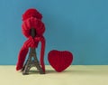 Christmas decoration with eiffel tower statue in red scraf and hat on colorful paper background. Holiday background with copy