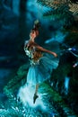 Christmas decoration figurine of a ballerina on a branch of a Christmas tree with blue lights