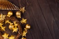 Christmas decoration - fir, glossy and glitter balls, wreath, golden stars on lights garland glowing on dark rich brown plank. Royalty Free Stock Photo