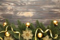 Christmas decoration. Fir-tree branch with gold balls, christmas flower and ribbon on brown Royalty Free Stock Photo