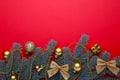 Christmas decoration. Fir-tree branch with gold balls, little gifts and bows on a red background Royalty Free Stock Photo