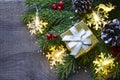 Christmas decoration with fir tree,golden gift box,garland lights and pine cones on old wooden background.Winter holidays,Merry Ch Royalty Free Stock Photo