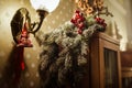 Christmas decoration with fir tree and holly berries as decor and lights with shadows. Close up