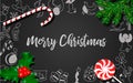 Christmas decoration with fir tree, holly berry, candy cane, lollypop on black chalkboard Royalty Free Stock Photo