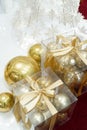 Christmas decoration in the form of gold Christmas balls in a package with a gold ribbon, white paper snowflakes, red Royalty Free Stock Photo