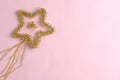 Christmas decoration in the form of a star on a pink background. Holiday concept, simple flat lay composition, top wiev