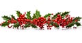 Christmas decoration garland from holly berries and leaves, with red ribbon on white background. Winter festive nature concept. Royalty Free Stock Photo