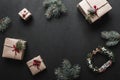 Christmas decoration, gift boxes and fir twigs, top view with copy space on black table surface Royalty Free Stock Photo